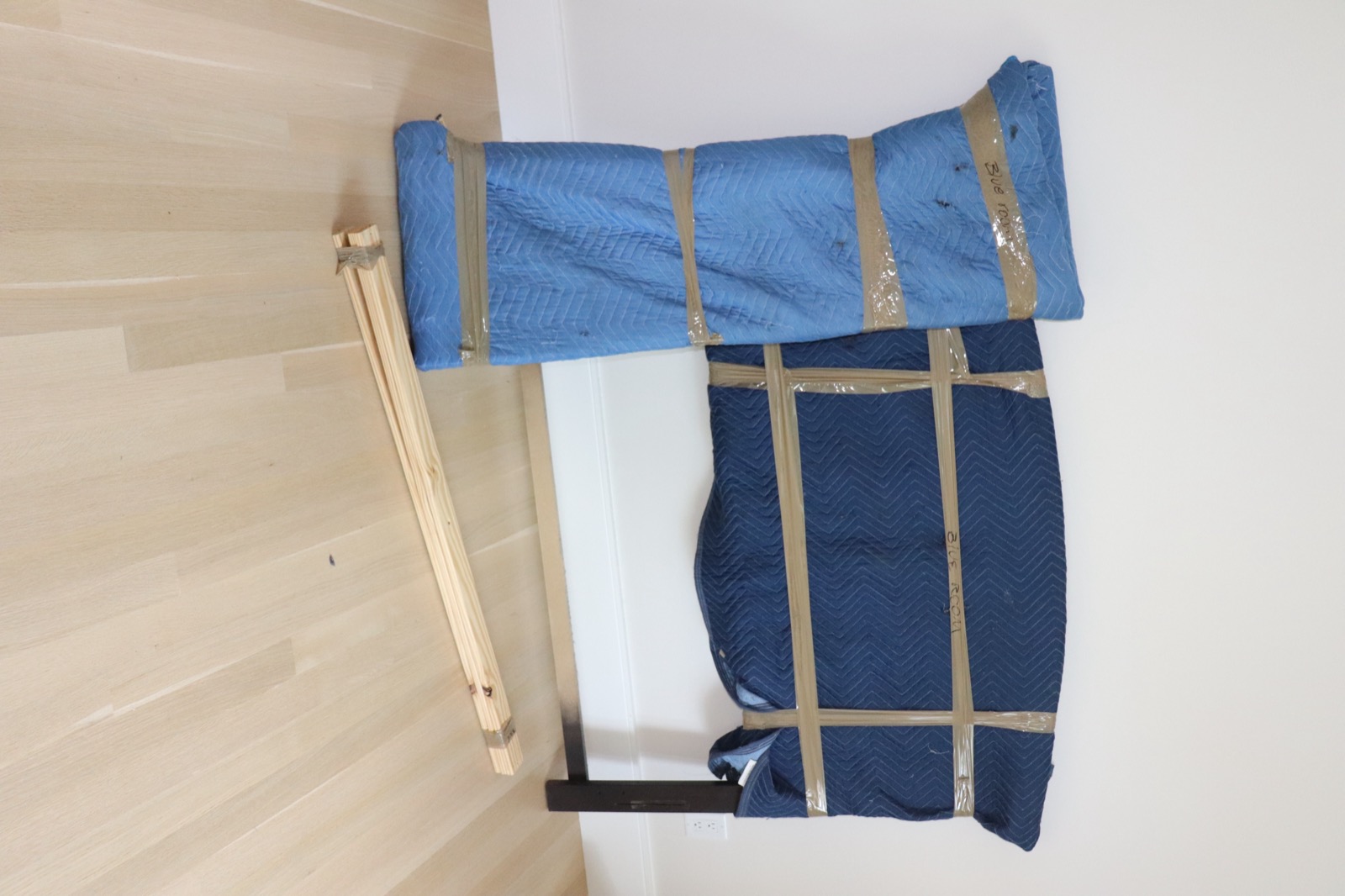 Bed frame carefully wrapped in protective moving blankets for safe transport