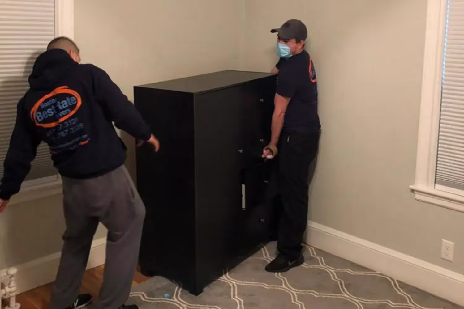Furniture movers wrapping and carrying large pieces